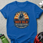 Blue t-shirt with "Built for Distance, Not Old, Just a Classic Machine, Still Clocking Miles" text and cyclist graphic.