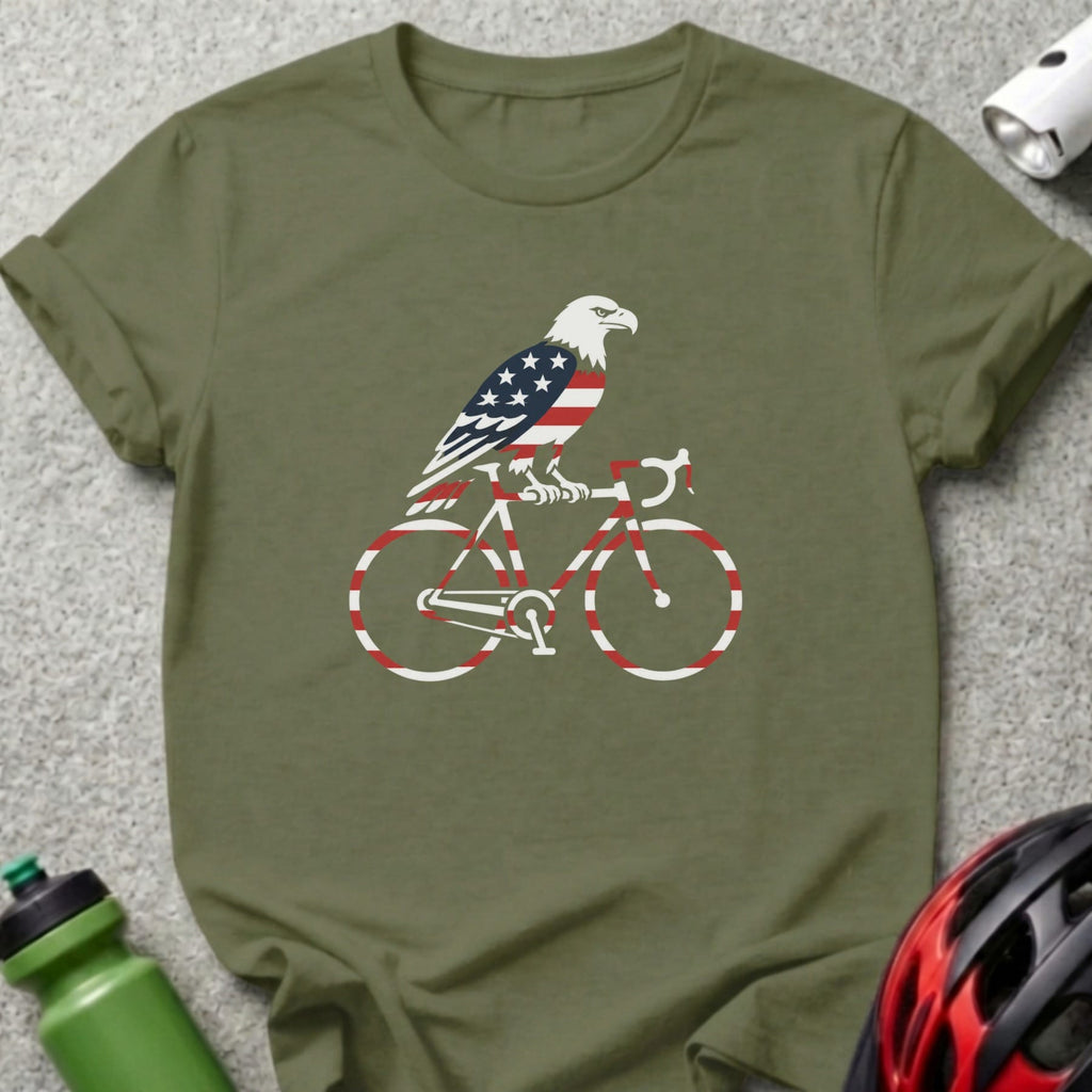 Eagle with American flag design riding a bicycle on a green t-shirt.
