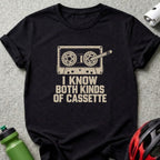 Black crewneck t-shirt featuring a cassette tape graphic with bicycle gears and the text I KNOW BOTH KINDS OF CASSETTE.