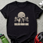 A black t-shirt features a tan graphic of a cyclist and dog on a road, with the text GOLDEN HOUR RIDE below.