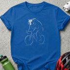 White line drawing of a bear riding a bicycle on a blue t-shirt.