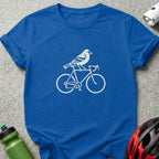 A royal blue t-shirt printed with a white graphic of a bird riding a bicycle.