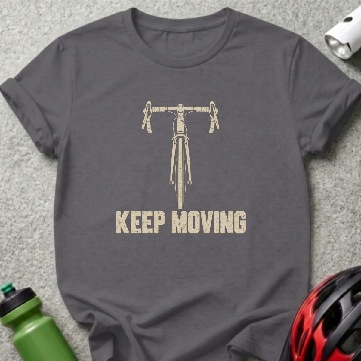 A dark gray t-shirt featuring a beige graphic of bicycle handlebars and the text KEEP MOVING.