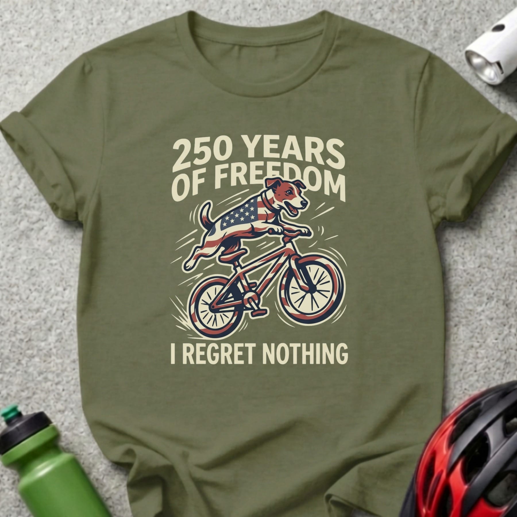 Olive green t-shirt with dog on bicycle, American flag, "250 Years of Freedom I Regret Nothing".