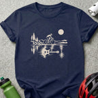 Dark blue t-shirt featuring a cream graphic of a cyclist with a guitar reflection in water.
