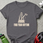 A dark gray t-shirt featuring a metronome graphic with a bicycle pedal pendulum and the text FIND YOUR RHYTHM.