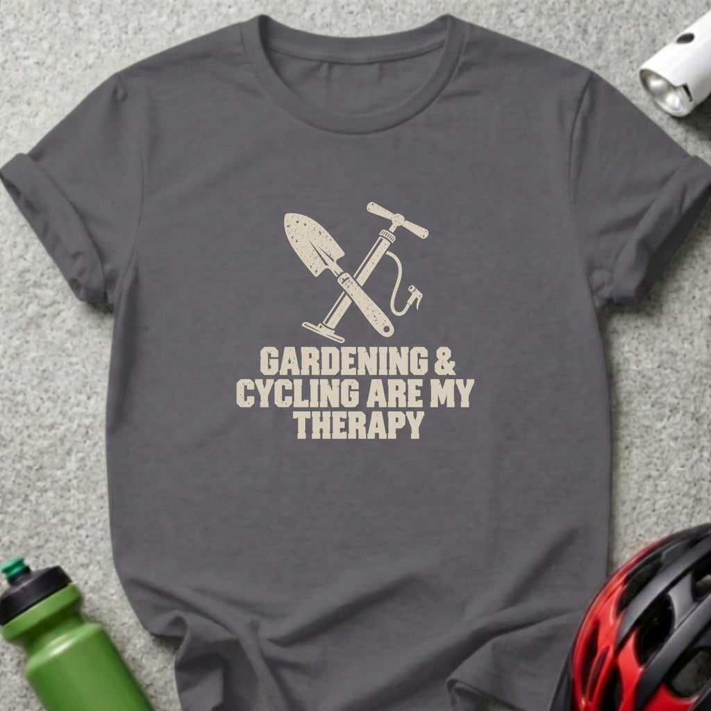 A dark gray t-shirt with a graphic of a shovel and tire pump crossed, accompanied by the text Gardening and Cycling are My Therapy.