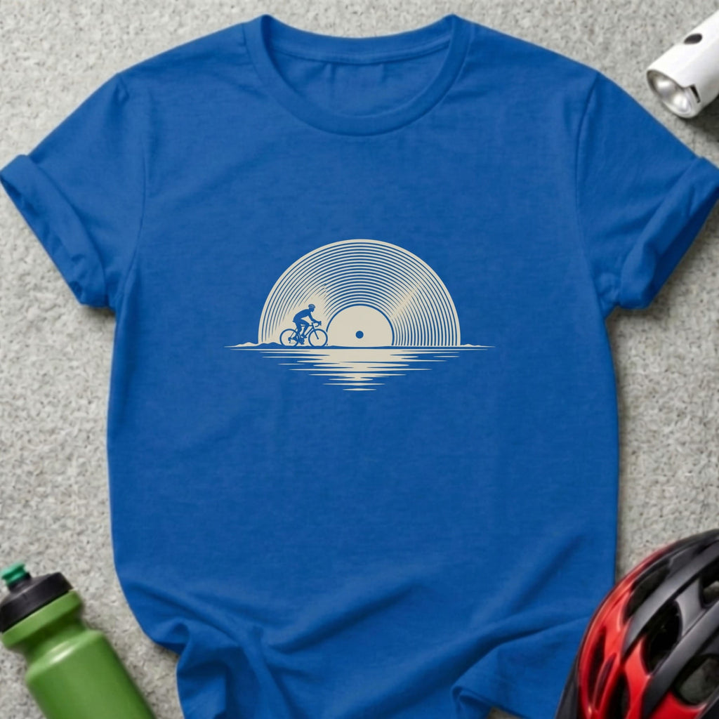 A blue crewneck t-shirt featuring a graphic of a cyclist riding across a vinyl record sun.