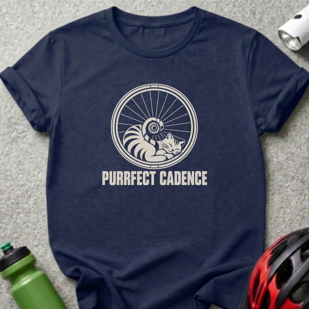 Dark blue t-shirt featuring a graphic of a sleeping cat inside a bicycle wheel with text reading PURRFECT CADENCE.