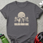 Dark grey t-shirt featuring a graphic print of a cyclist and dog on a road at sunset, with the text Golden Hour Ride.