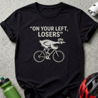 Black t-shirt with graphic of a chicken on a bicycle and text "ON YOUR LEFT, LOSERS".