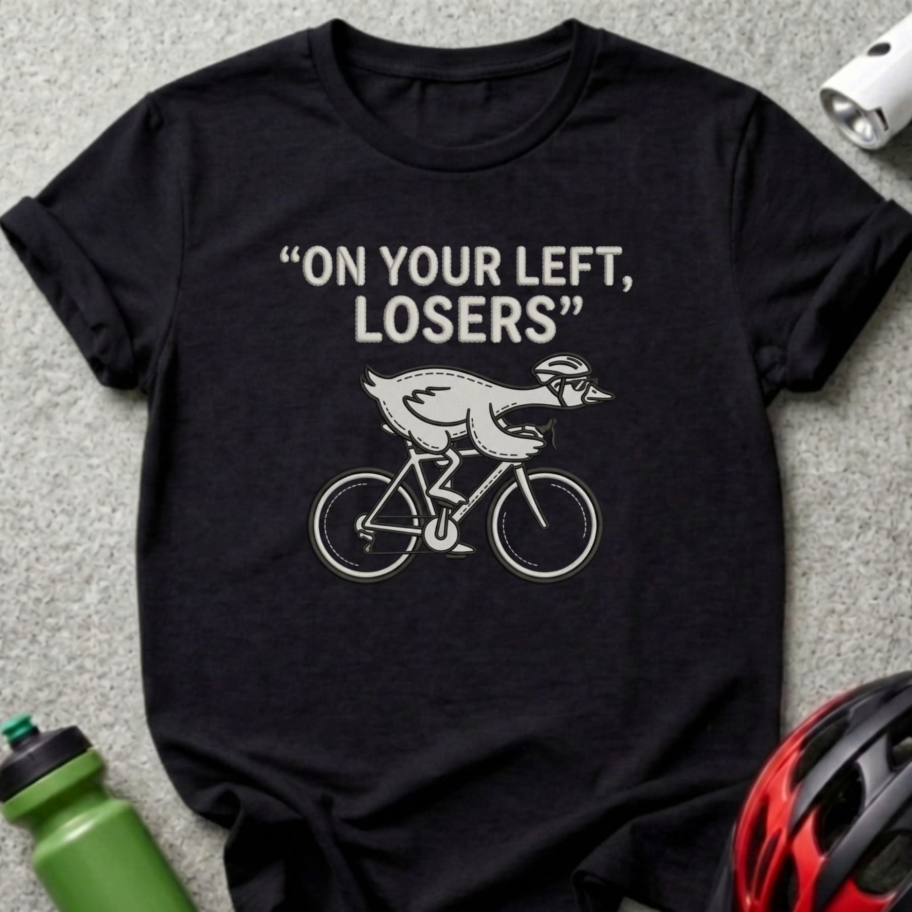 Black t-shirt with graphic of a chicken on a bicycle and text "ON YOUR LEFT, LOSERS".
