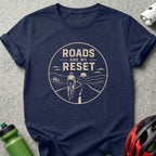 Dark blue t-shirt with a circular graphic of a cyclist on a winding road and text.