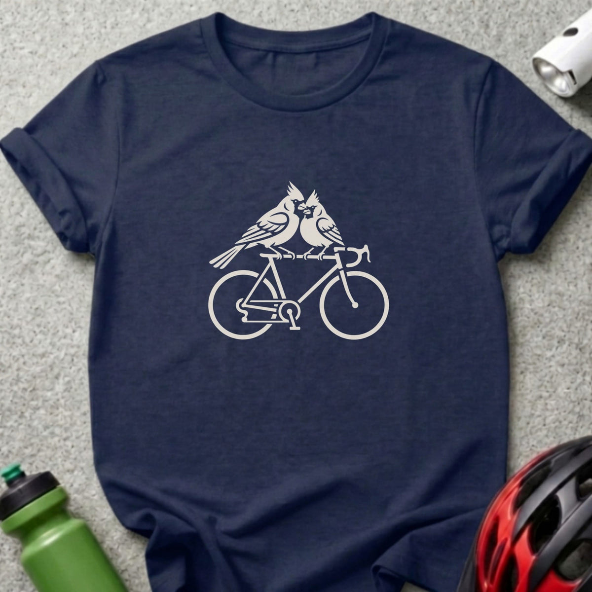 A dark blue t-shirt printed with a white graphic of two birds riding a bicycle.
