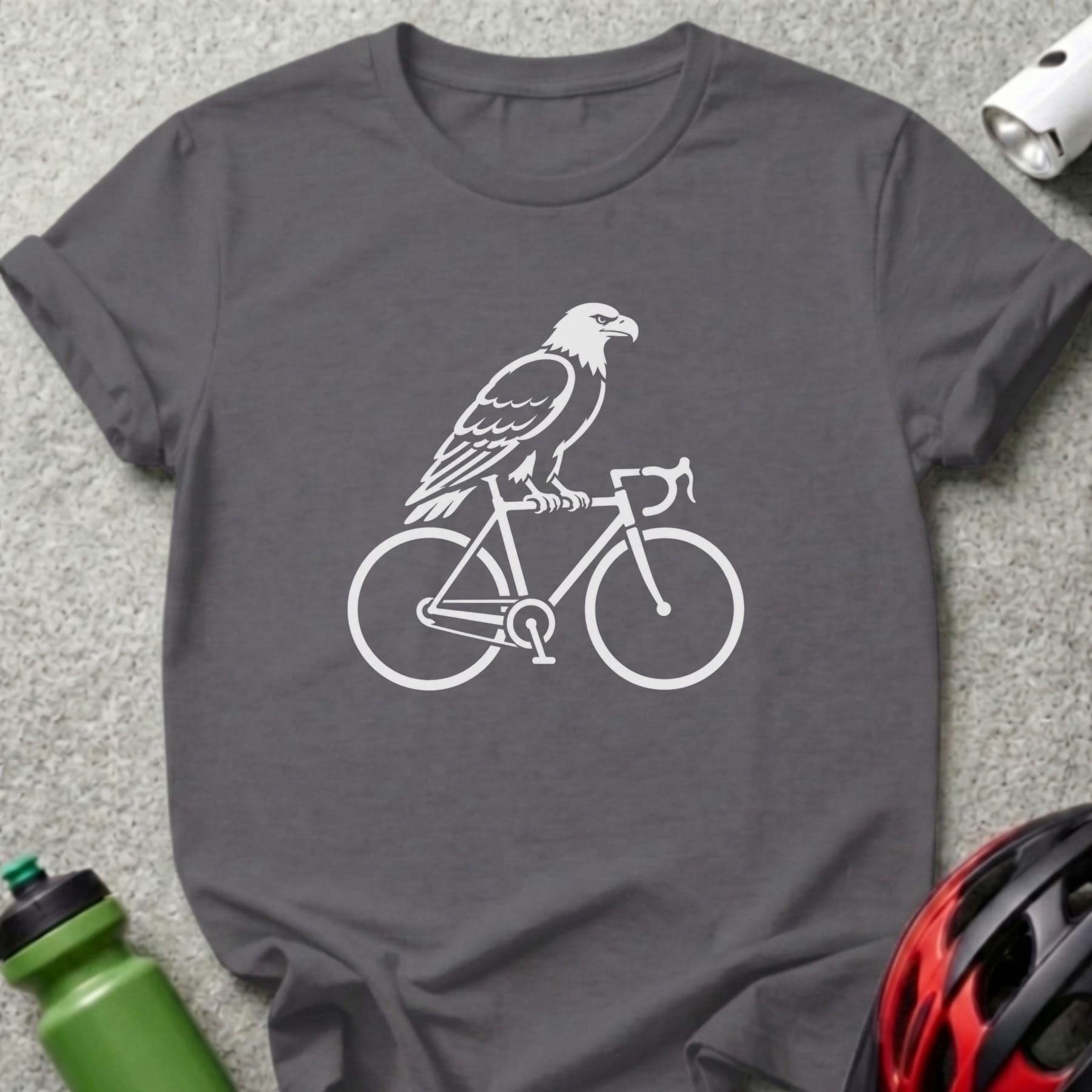 White eagle silhouette riding a bicycle on a dark gray t-shirt.
