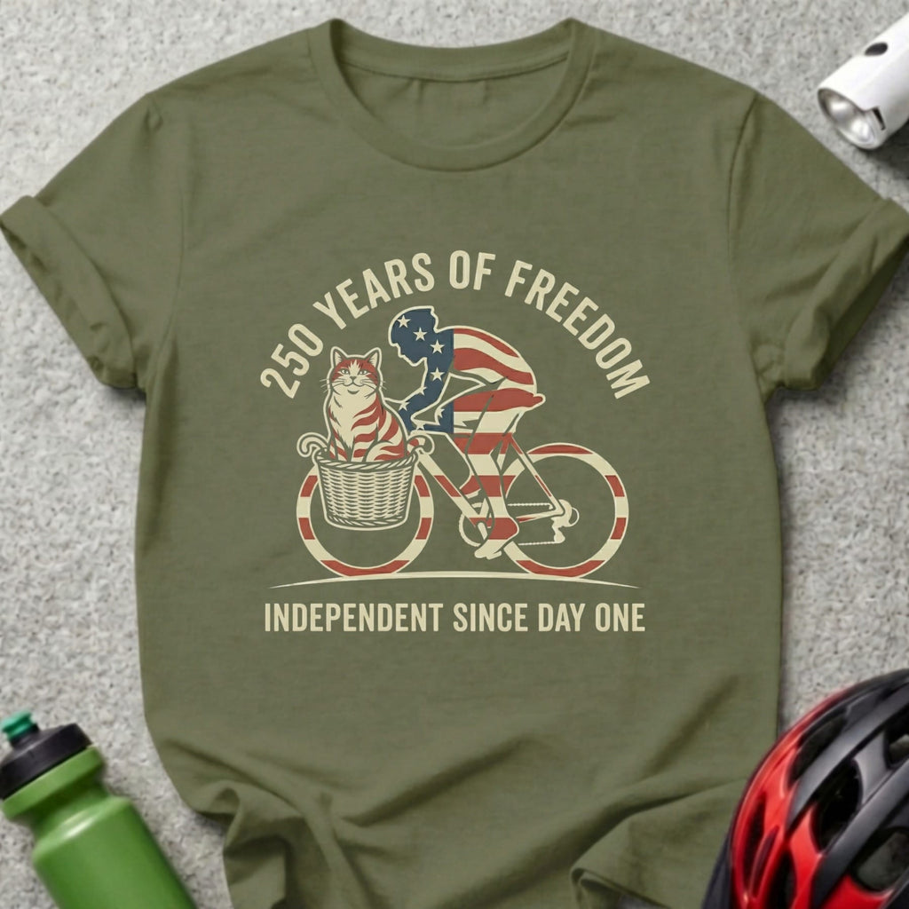 Green t-shirt with cat on bicycle graphic, "250 YEARS OF FREEDOM" and "INDEPENDENT SINCE DAY ONE".