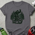 Bigfoot riding a bicycle through a forest.