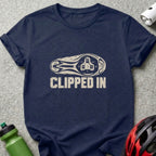 A dark blue crew-neck t-shirt with a distressed graphic of a bicycle cleat and the text CLIPPED IN.