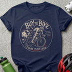 Navy t-shirt with cyclist and piggy bank graphic, text reads "BUY THE BIKE FIGURE IT OUT LATER"
