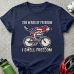 Dog wearing American flag bandana rides bicycle, text "250 Years of Freedom I Smell Freedom".
