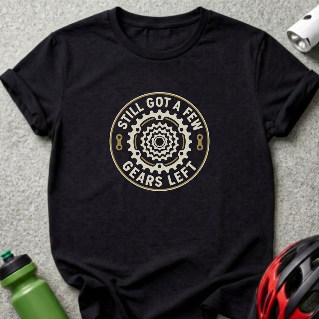A black t-shirt features a circular bicycle gear graphic with the text "STILL GOT A FEW GEARS LEFT".
