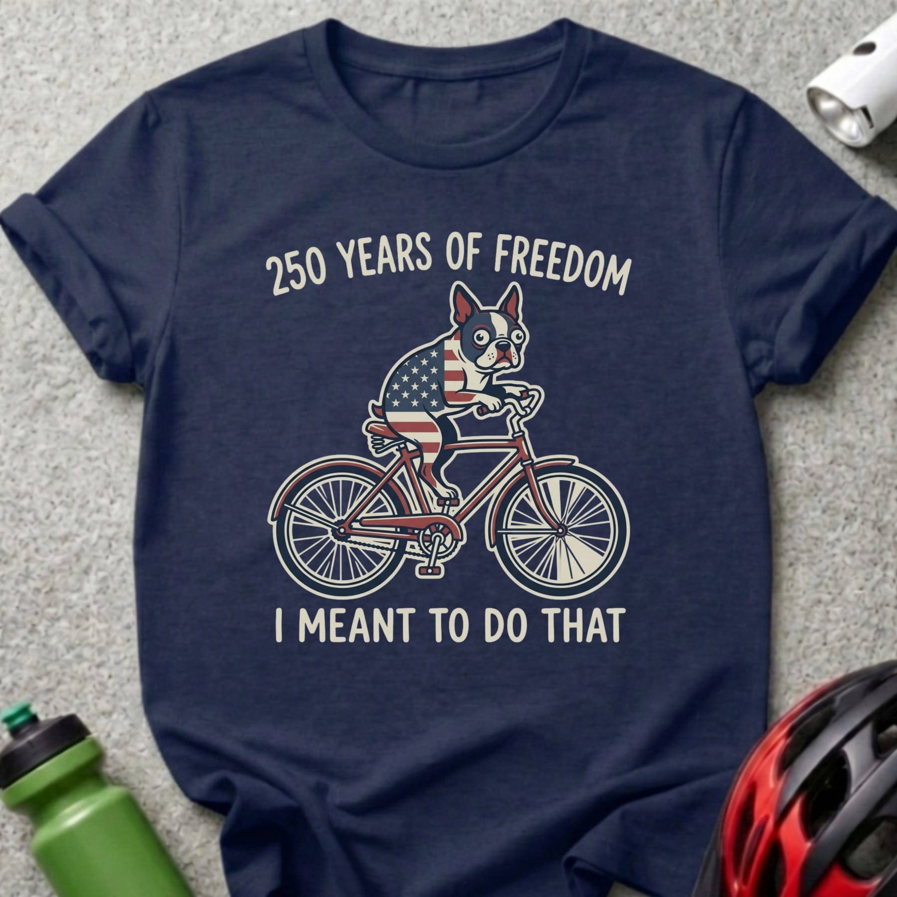 French bulldog wearing American flag bandana rides bicycle, "250 Years of Freedom I Meant to Do That" text.