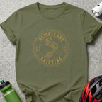 Olive green t-shirt with circular graphic of bike derailleur and text "SEVENTY AND SHIFTING".