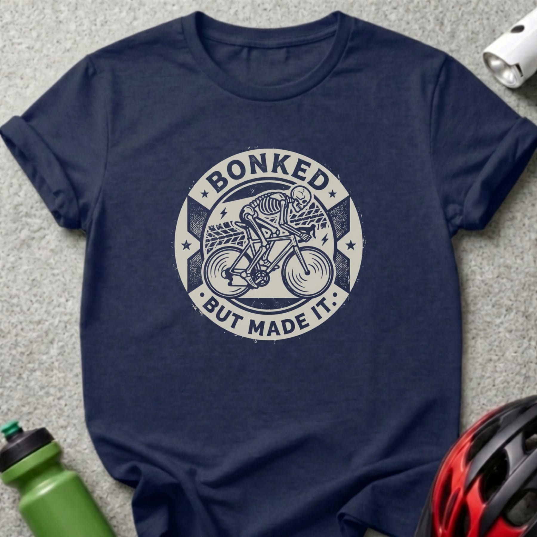 Navy t-shirt with "Bonked but made it" text and skeleton cyclist graphic.