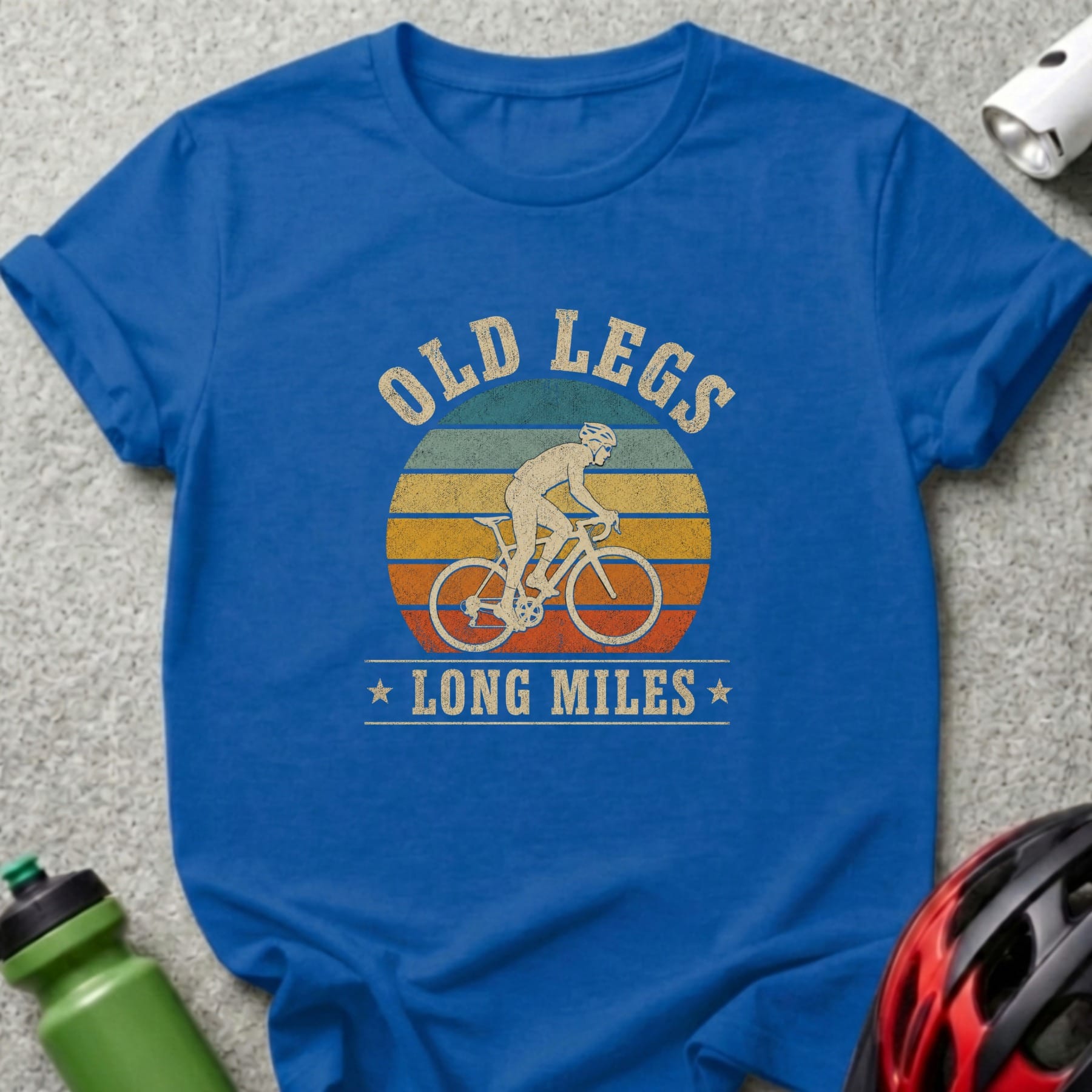 Blue t-shirt with a cyclist silhouette and text "OLD LEGS LONG MILES".