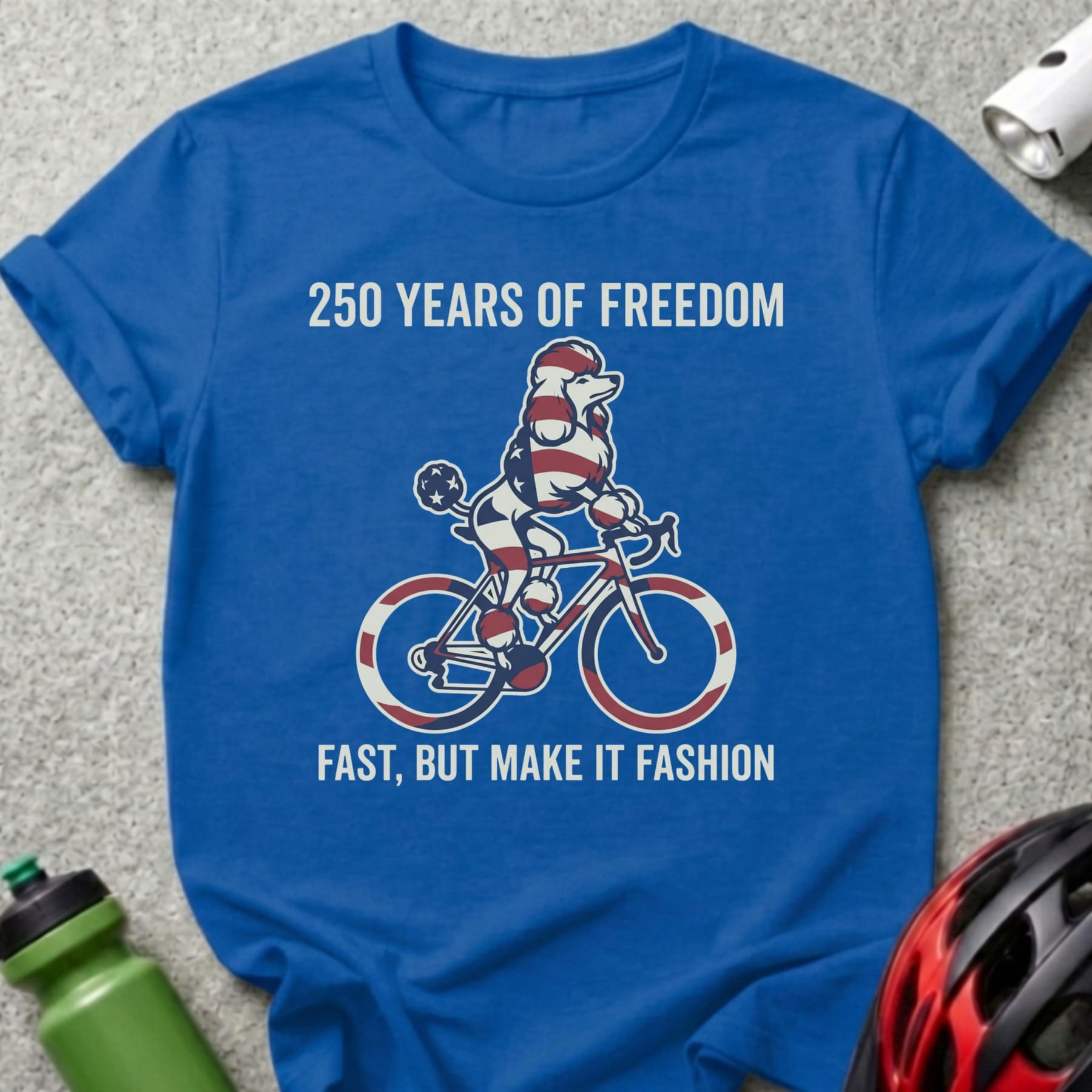 Blue t-shirt with poodle on bicycle graphic and text "250 Years of Freedom".