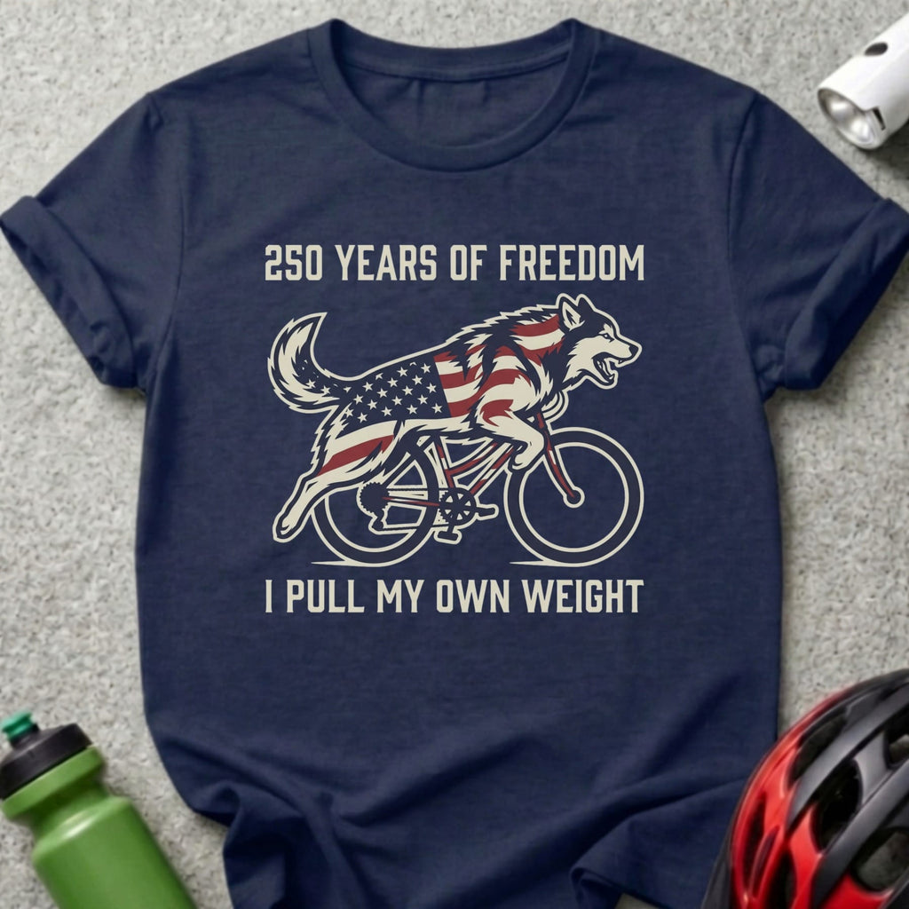 Navy t-shirt with wolf on bicycle, American flag, "250 YEARS OF FREEDOM I PULL MY OWN WEIGHT" text.