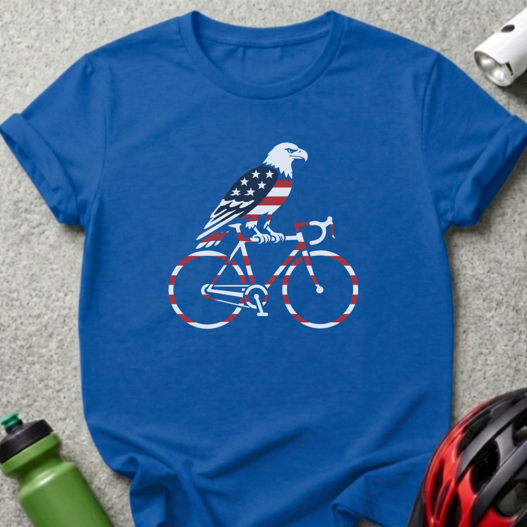Blue t-shirt with an eagle riding a bicycle with American flag details.