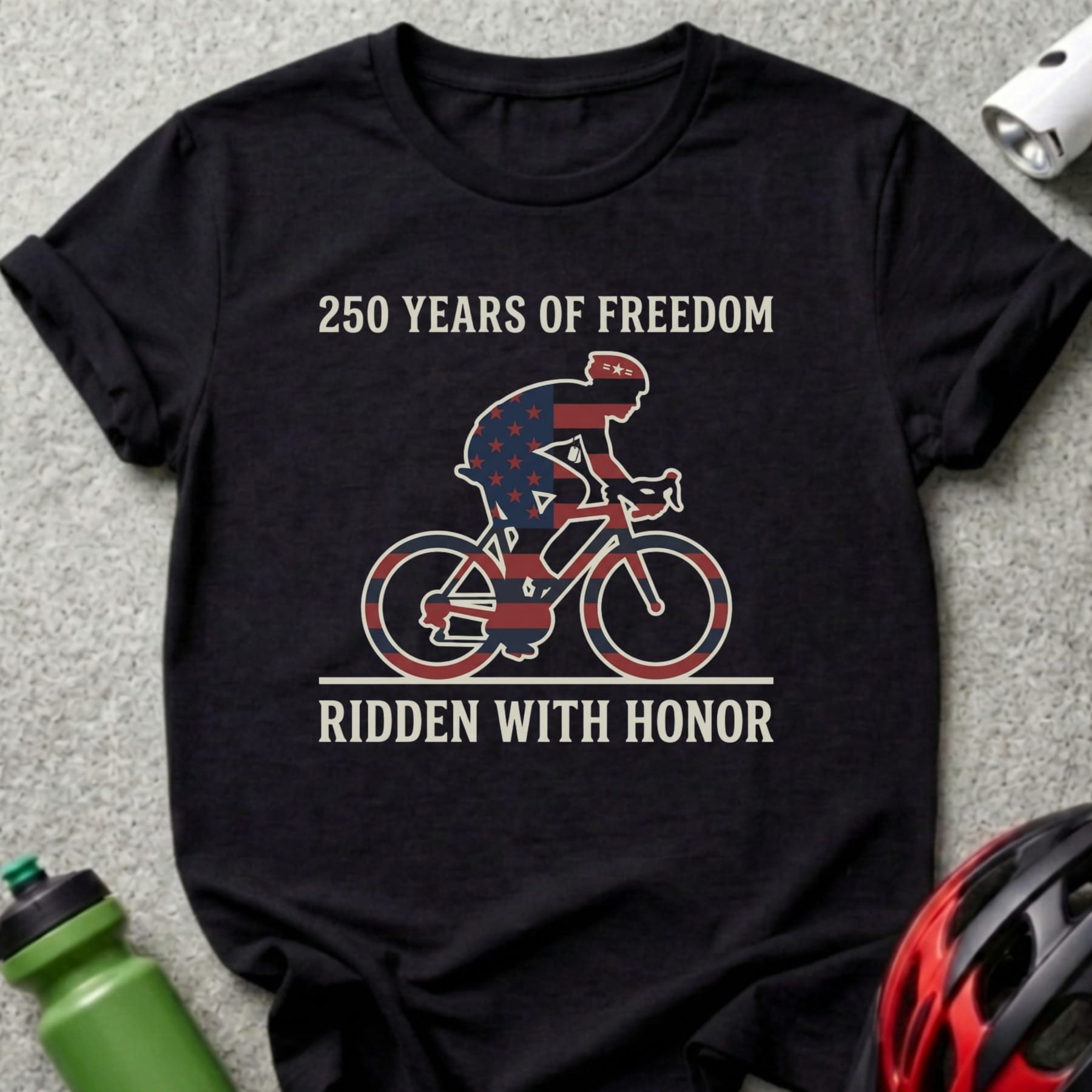 Black t-shirt with cyclist wearing USA flag pattern, "250 Years of Freedom, Ridden With Honor" text.