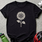 A black t-shirt printed with a beige graphic of a sunflower featuring a bicycle gear center.