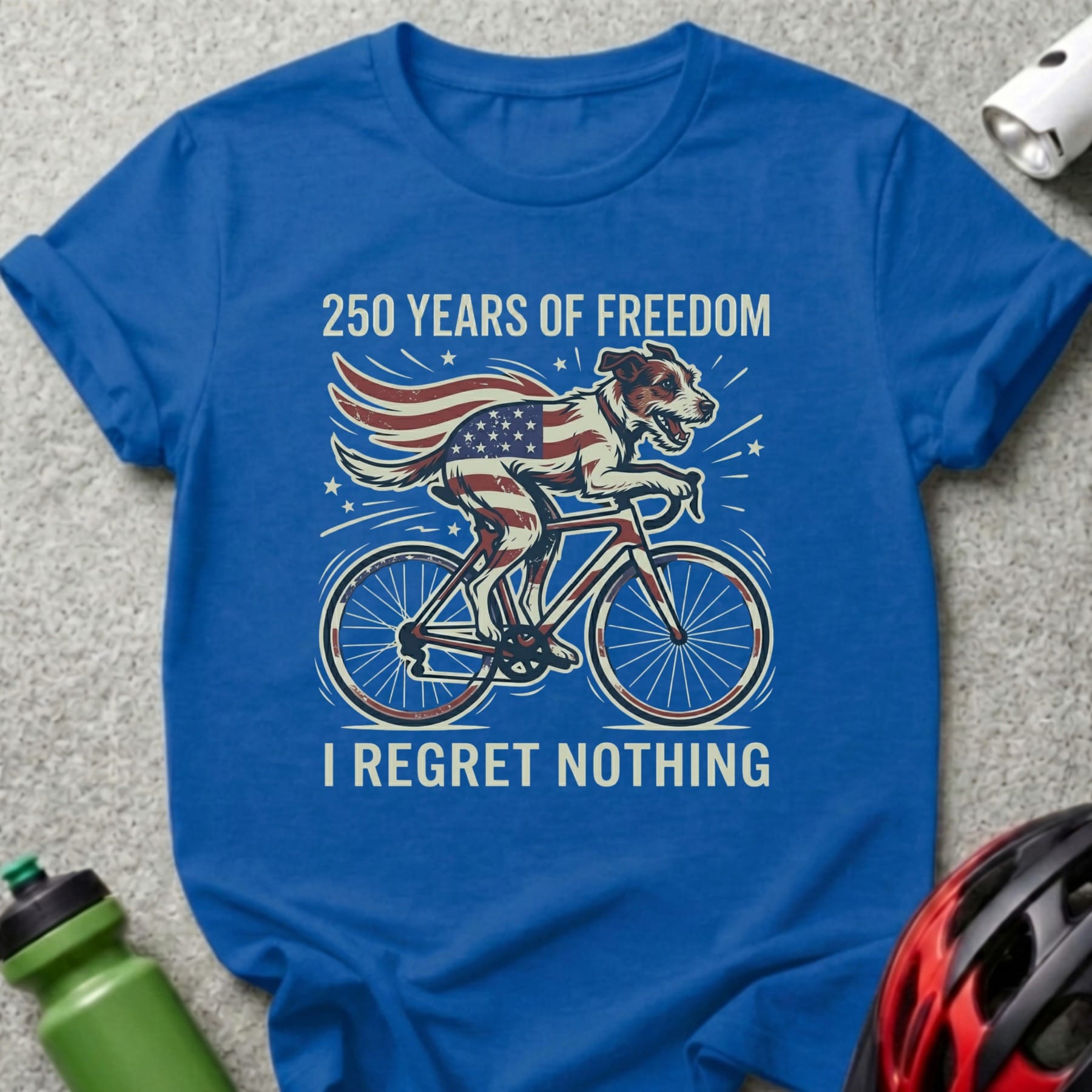 Blue t-shirt with dog on bicycle, US flag, "250 Years of Freedom I Regret Nothing".