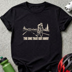 A black t-shirt printed with a graphic of cyclists on a road and text reading THE ONE THAT GOT AWAY.