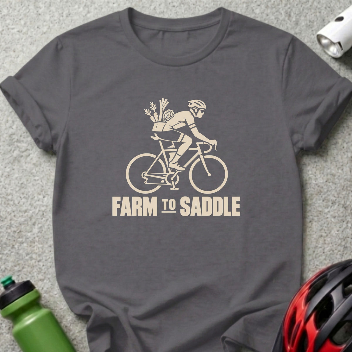 Dark gray crewneck t-shirt featuring a cream graphic of a cyclist carrying vegetables, with the text FARM TO SADDLE.