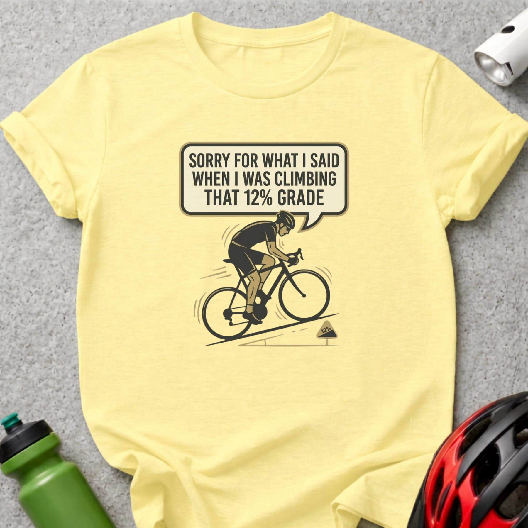 Yellow t-shirt with a cyclist graphic and "Sorry for what I said when I was climbing that 12% grade" text.
