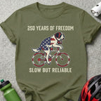 St. Bernard on bicycle, American flag pattern, text "250 Years of Freedom" and "Slow But Reliable".