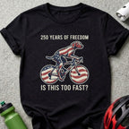 T-shirt with dog on bicycle, American flag pattern, and text "250 YEARS OF FREEDOM IS THIS TOO FAST?"