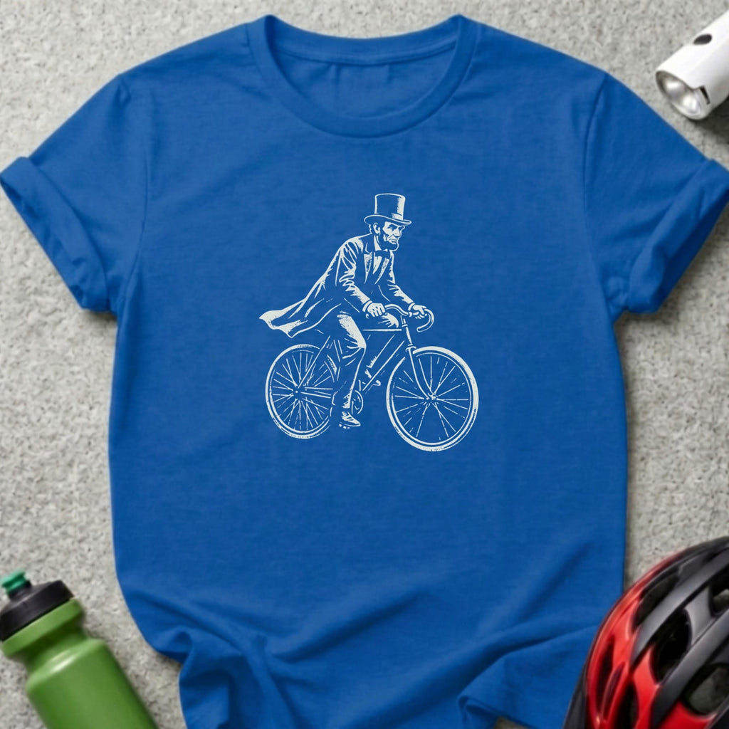 Blue t-shirt with white graphic of Abraham Lincoln riding a bicycle.