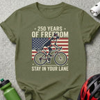 German Shepherd on bicycle with American flag and "250 Years of Freedom" text.