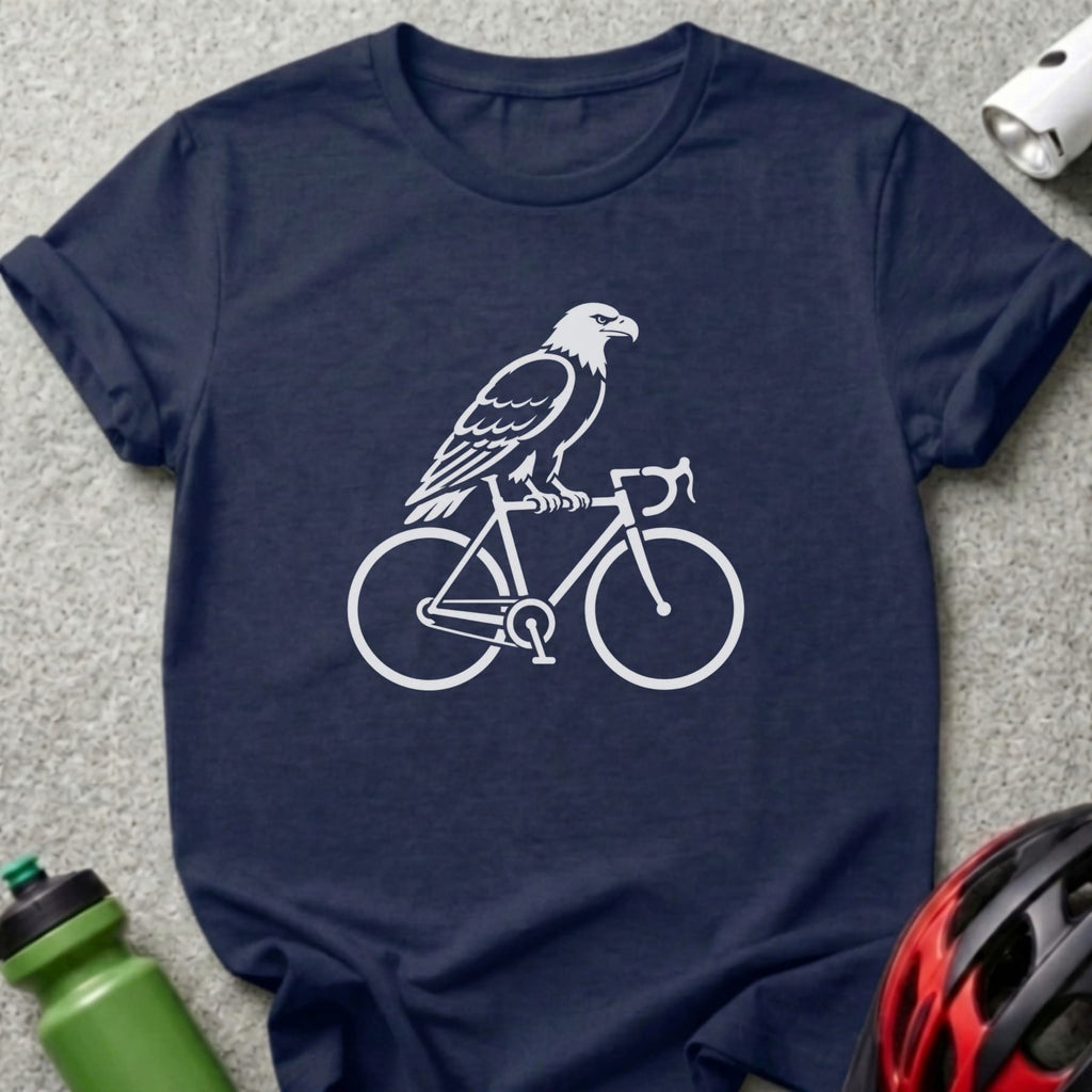 White eagle perched on a bicycle silhouette on a navy blue t-shirt.