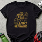 Black t-shirt with a graphic of a cyclist and text "CRANKY INTO THE HEADWIND".