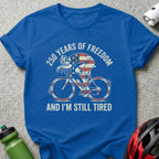 Blue t-shirt with cyclist graphic and text "250 YEARS OF FREEDOM AND I'M STILL TIRED".