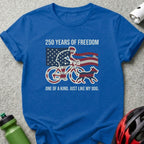 Blue t-shirt with a cyclist and dog illustration, American flag, and text.
