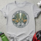 Grey t-shirt with "Ride to Escape" and cyclist in city graphic.