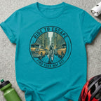 Turquoise t-shirt with circular graphic of cyclist escaping traffic, "Ride to Escape" and "Find Your Way Out".