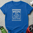 Blue t-shirt featuring a white graphic of a seed packet labeled "Road Bike Seeds" with bicycle illustrations.