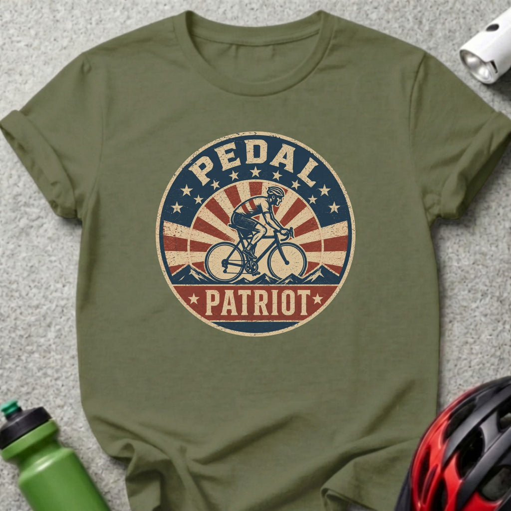 Olive green t-shirt with vintage "Pedal Patriot" graphic of cyclist and American flag elements.